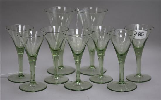 Attributed to James Powell & Sons, circa 1900, a part suite of nine green-tinted trumpet-shaped wine glasses,